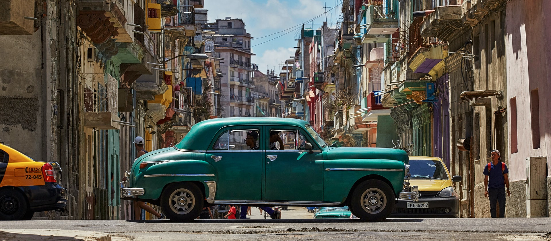 Vintage car driving along a street in Cuba